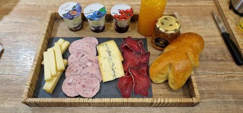 un vassoio di diversi tipi di formaggio e pane di La Dame - Parking Privé GRATUIT Proche GE Alstom & Centre-Ville a Cravanche