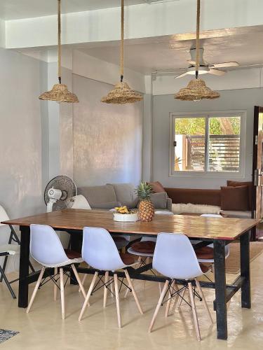 a dining room with a table and white chairs at Bahai ni Jhane in Calatagan