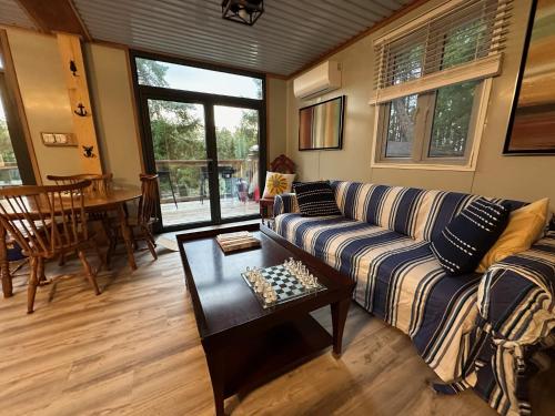 a living room with a couch and a table at Thetis Island Get Away Cottage in North Galiano