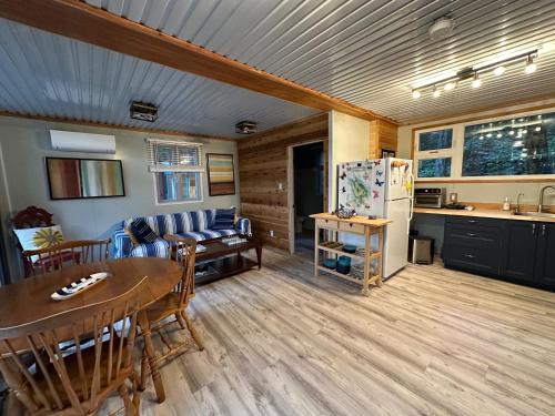 a kitchen and living room with a table and a refrigerator at Thetis Island Get Away Cottage in North Galiano