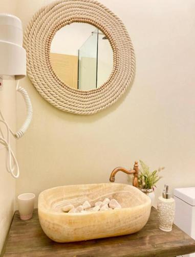 a bathroom with a stone sink and a mirror at Old Town Suites Muradie in Vlorë