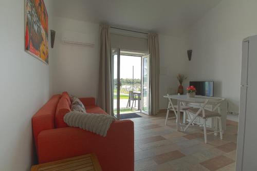 a living room with a red couch and a table at Monte das Perdizes in Olhão