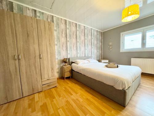 a bedroom with a large bed and wooden floors at Le Miraumont - Centre - Jardin in Calais