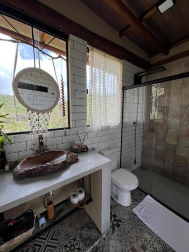 a bathroom with a sink and a toilet and a shower at Rustik in Alto Paraíso de Goiás