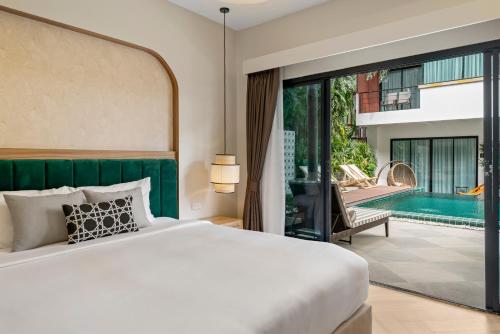 a bedroom with a bed and a swimming pool at Buasri Boutique Patong in Patong Beach
