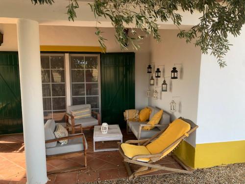 a patio with chairs and a couch and a table at Courela da Anta in Vimieiro