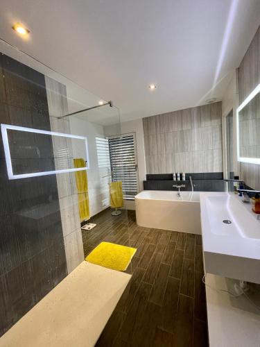 une salle de bain avec une baignoire et un lavabo dans l'établissement Luxueuse villa Annecy, à Argonay