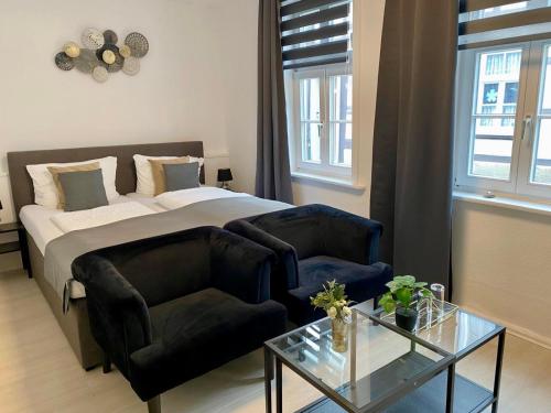 a bedroom with a bed and a couch and a table at Altstadt-Hotel Gosequell in Goslar