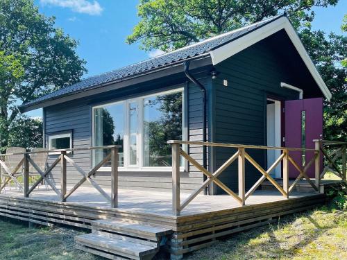 a black tiny house with a large deck at 4 star holiday home in HENÅN in Henån