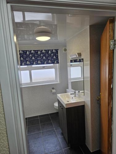 a bathroom with a sink and a toilet and a window at Castle By The Sea Scarborough in Scarborough