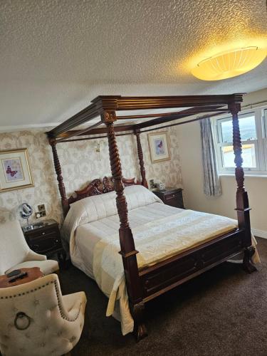 a bedroom with a canopy bed and a chair at Castle By The Sea Scarborough in Scarborough