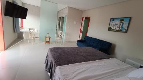 a bedroom with a bed and a blue couch in it at Suítes Nossa Senhora de Fátima in Pirenópolis