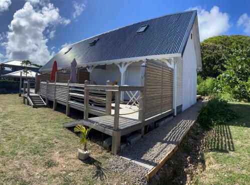 a small cabin with a porch and a roof at KaZa Bielle in Capesterre-de-Marie-Galante
