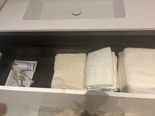a drawer with three towels and a sink at Studio Starnberg in Starnberg