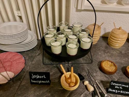 a tray of glasses of milk on a table with plates at Altstadt-Hotel Gosequell in Goslar