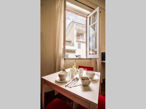 a white table topped with a white plate next to a window at Liolà Palermo in Palermo