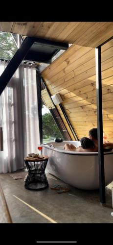 a bath tub in a room with a wooden ceiling at Chalé Panorama in Munhoz