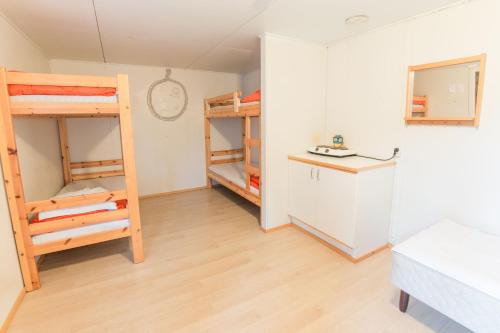 a room with two bunk beds and a refrigerator at Tampere Camping Härmälä in Tampere