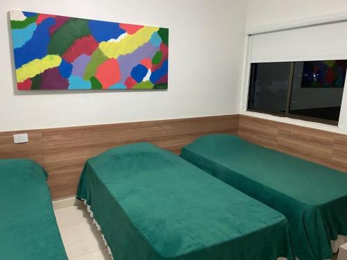 a room with two green beds and a window at HOTEL CANARIUS DE GRAVATA - Flat in Gravatá