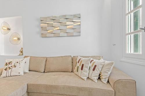 a white living room with a couch with pillows at Heart of Mykonos Suites in Mýkonos City