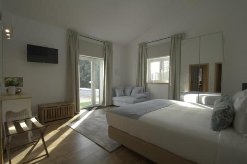 a bedroom with a bed and a couch and a television at Monte das Perdizes in Olhão