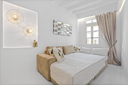 a white room with a couch and a window at Heart of Mykonos Suites in Mýkonos City