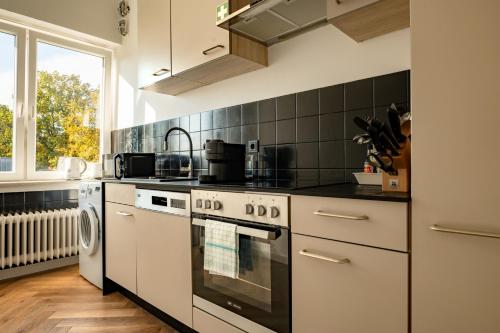 a kitchen with a stove top oven next to a window at Airport Apartment für 4 - Smart TV - Küche - eCharger in Hamburg