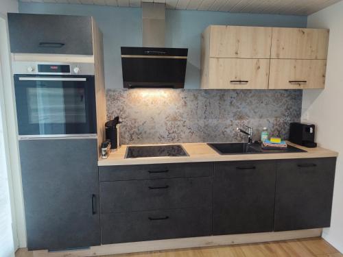 a kitchen with a sink and a stove at Apartment Kleine Auszeit - stylish & cozy in Spiez