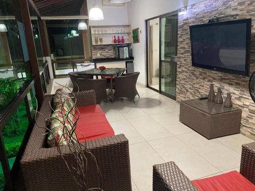 a living room with a television and a table and chairs at HOTEL CANARIUS DE GRAVATA - Flat in Gravatá