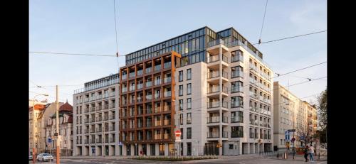 a tall building on a city street with buildings at Luxurious Vanilla Apartment, self check-in 24h, free parking, air-conditioning in Poznań