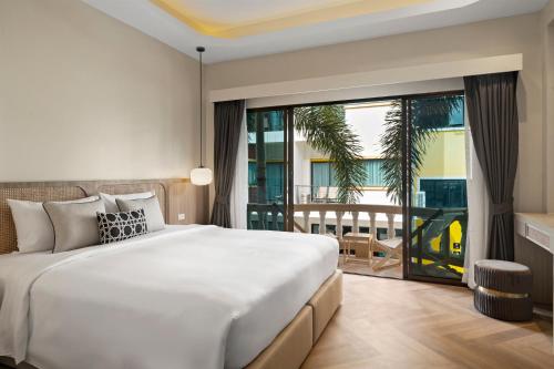 a bedroom with a large bed and a large window at Buasri Boutique Patong in Patong Beach