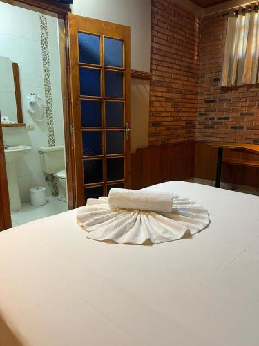 a bed with two white towels on top of it at Status Motel Ourinhos in Ourinhos