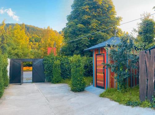 a garden with a red shed and a fence at Green Garden Guest House in Dilijan