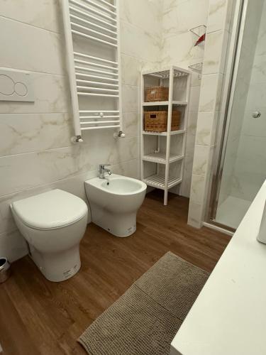 a white bathroom with a toilet and a sink at Casa Tyffany in Busto Arsizio
