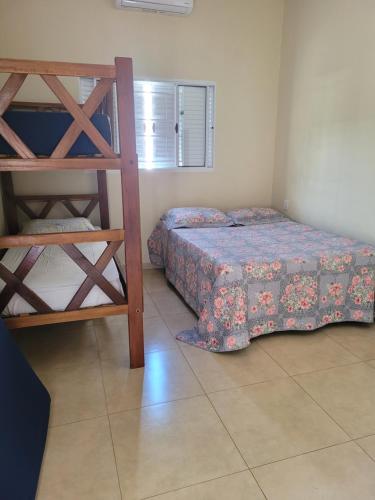 a bedroom with a bed and a bunk bed at Casa Temporada Nosso Recanto Piscina aquecimento Solar in Olímpia