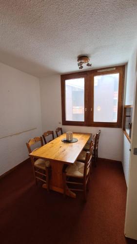 une salle à manger avec une table et des chaises en bois dans l'établissement Belle-Plagne, skis aux pieds, à La Plagne Tarentaise