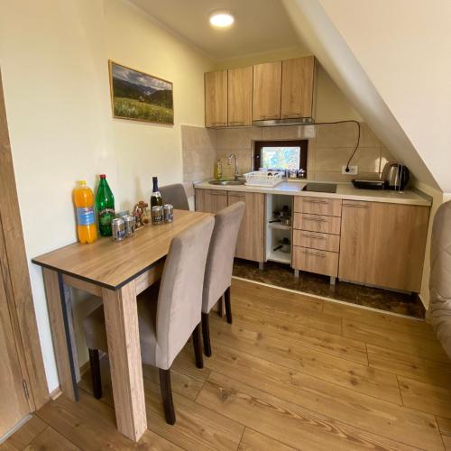a kitchen with a wooden table and chairs in a room at Vila Mirjana Tara in Kaludjerske Bare