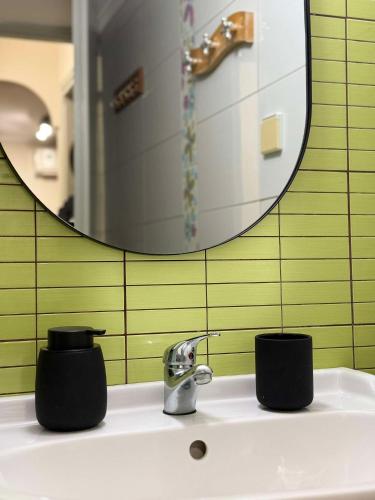 a bathroom sink with a faucet and a mirror at The Little Blooming House in Agíasma