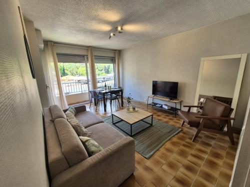 una sala de estar con un sofá y una mesa en Apartment 6 minutes from Monaco train station, en Beausoleil