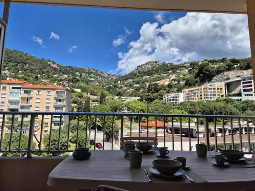 Una mesa en un balcón con vista a una ciudad. en Apartment 6 minutes from Monaco train station, en Beausoleil