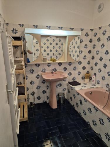 La salle de bains est pourvue d'un lavabo rose et d'une baignoire. dans l'établissement Apartment 6 minutes from Monaco train station, à Beausoleil