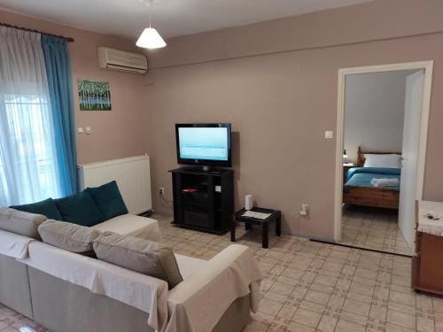 a living room with a couch and a flat screen tv at Σαν Στο Σπίτι Σας in Xanthi