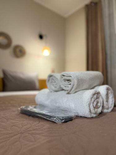 a pile of towels sitting on top of a bed at The Little Blooming House in Agíasma