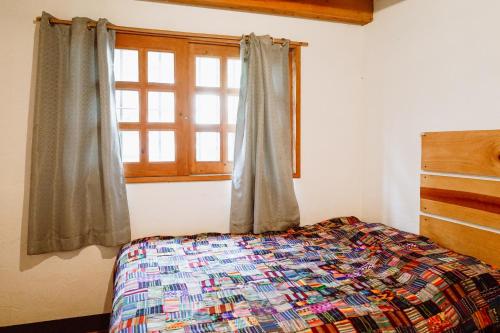 a bedroom with a bed and a window at Casa Mike, San Marcos La Laguna in San Marcos La Laguna
