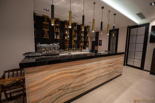 a bar in a room with a counter with lights at PineHill Hotel, Restaurant , Pool & Spa - RAZEM in Razëm