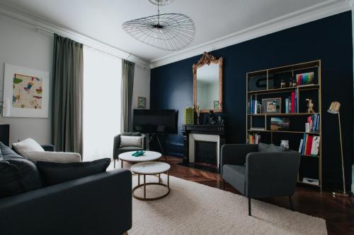 a living room with a couch and chairs and a mirror at L'appartement - Meursault in Meursault