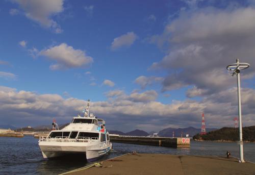 a white boat is docked in the water at Grand Prince Hotel Hiroshima in Hiroshima