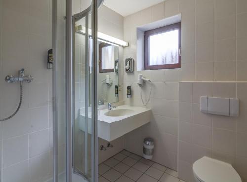 a bathroom with a sink and a shower at Berggasthof & Hotel Kranich in Eisfeld