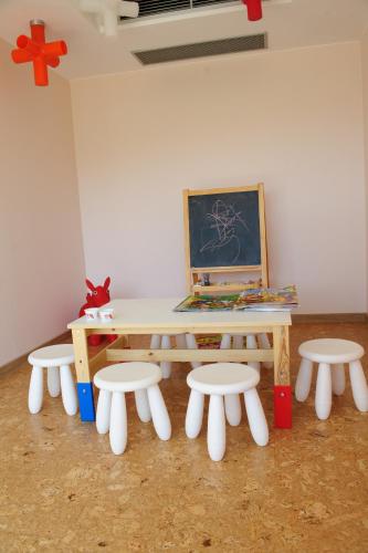 a table and four chairs with a painting on the wall at Ruskovets Thermal SPA & Ski Resort in Bansko