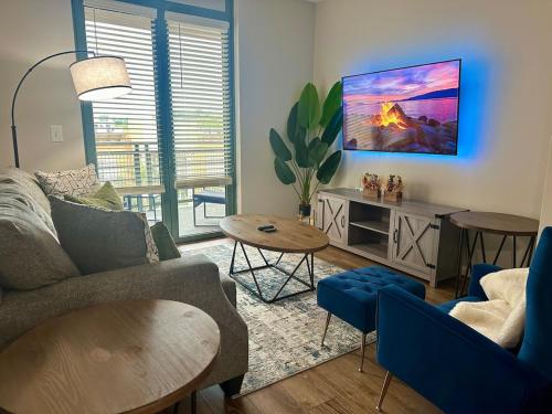 a living room with a couch and a tv at Beautiful Arlington Apartment with Pool & Parking! in Arlington